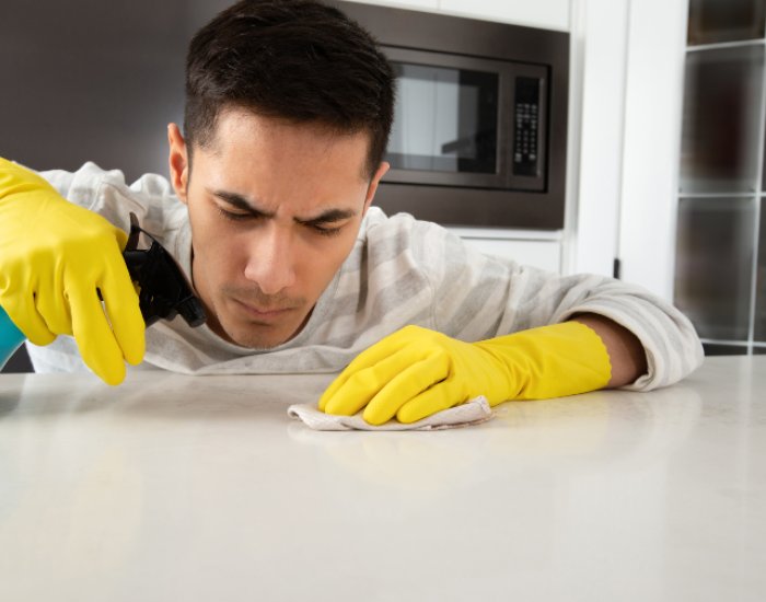 A person cleaning a Quartz Countertop island in Utah County, UT