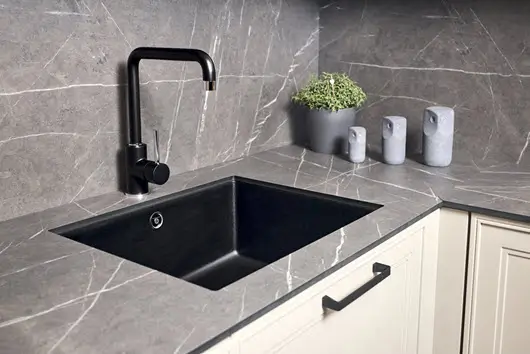 Gray porcelain countertop with elegant white veining, featuring a sleek modern sink and faucet in a minimalist kitchen design.