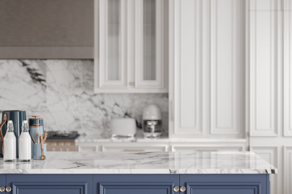 Modern kitchen featuring a blue kitchen island with a white marble countertop, adorned with wooden utensils, glass bottles, and ceramic containers.