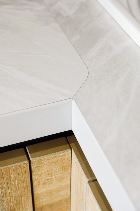 Close-up of a seamless corner joint in light-colored granite countertops, showcasing a rounded edge design and clean craftsmanship to minimize visible seams