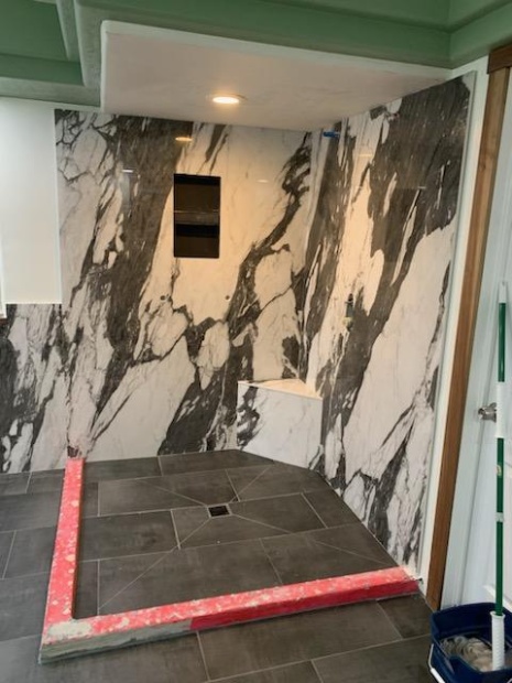 Porcelain slab shower walls with dramatic veining and built-in bench