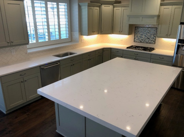 Modern kitchen with white quartz countertops and large center island