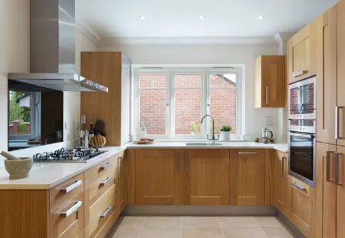 Modern kitchen with oak cabinets and light countertops creating a warm, balanced design
